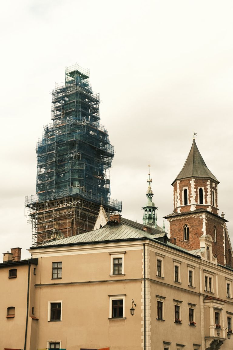 Kirchturm über die volle Höhe eingerüstet und mit grünem Netz verkleidet